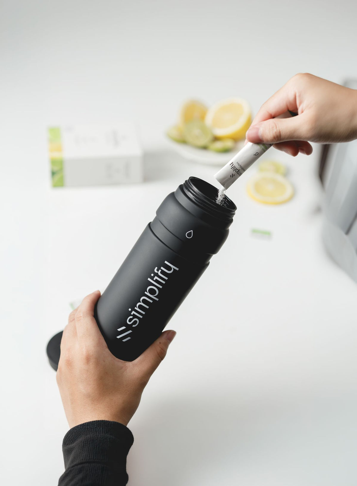 Secret Salt Sports Bottle with cap open, electrolyte sachet being poured in