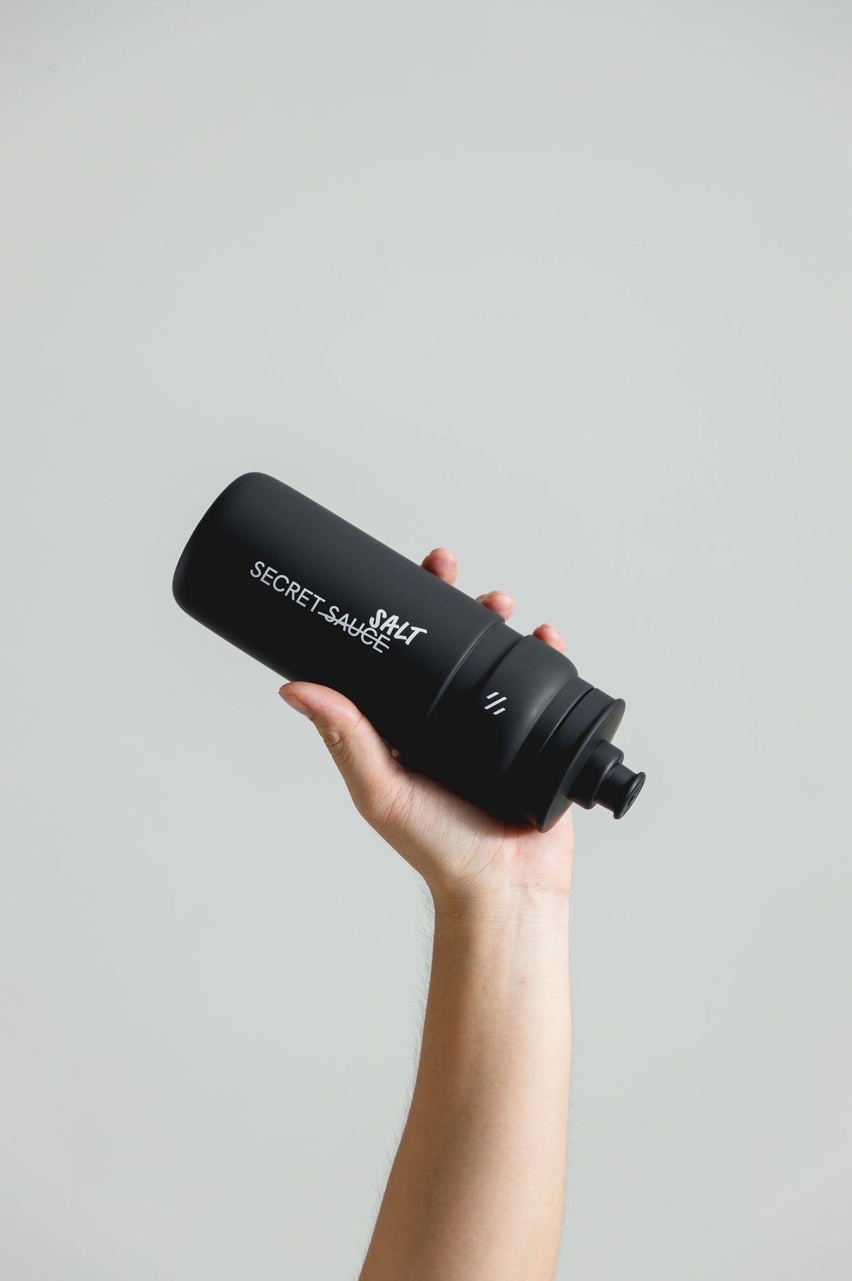 Secret Salt Sports Bottle held up, showing the SALT print and cap